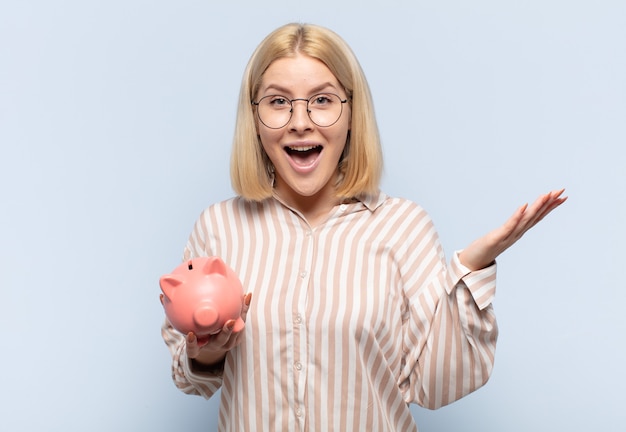 Mujer rubia que se siente feliz, sorprendida y alegre, sonriendo con actitud positiva, dándose cuenta de una solución o idea