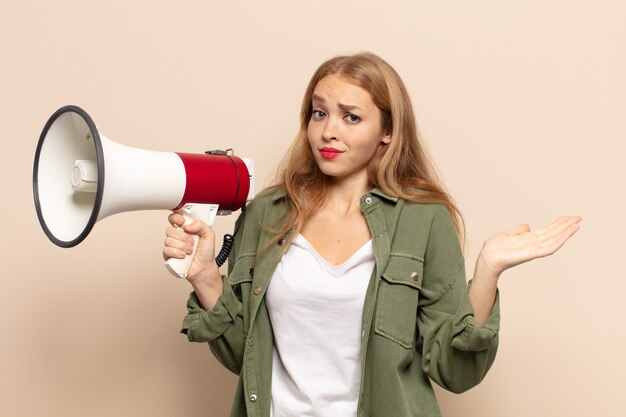 Mujer rubia que se siente perpleja y confundida, dudando, ponderando o eligiendo diferentes opciones con expresión divertida