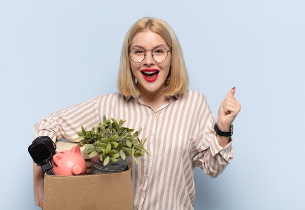 Mujer rubia que se siente sorprendida, emocionada y feliz, riendo y celebrando el éxito, diciendo ¡guau!