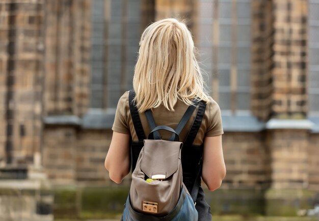 Mujer rubia se queda cerca de la iglesia medieval en Europa