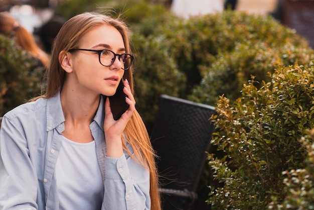 Foto mujer rubia segura hablando por teléfono