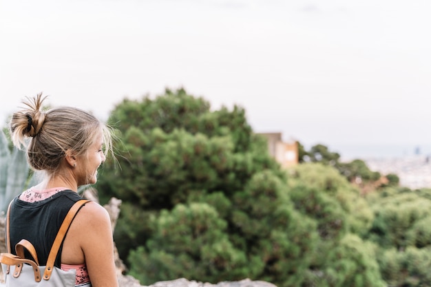 Mujer rubia sonriente que se coloca en un puesto de observación.