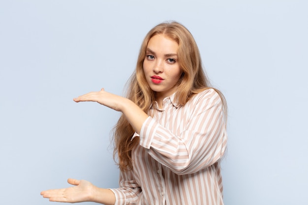 Mujer rubia sosteniendo un objeto con ambas manos a los lados