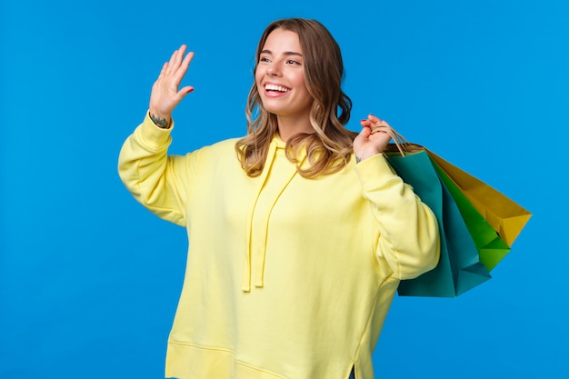 Mujer rubia en una sudadera amarilla