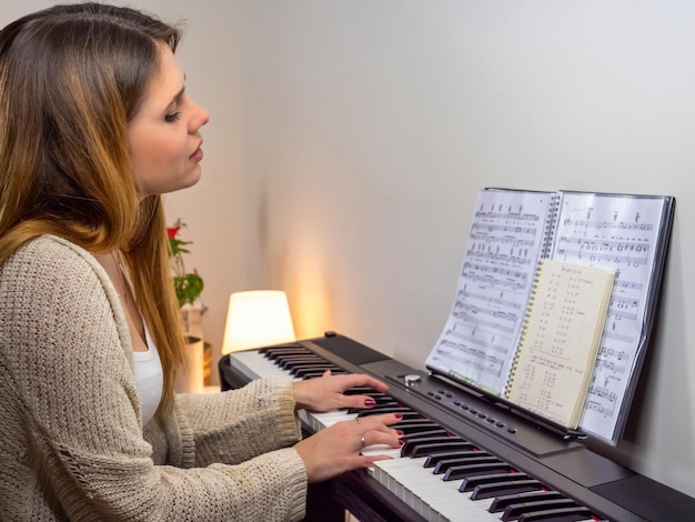 mujer rubia tocando el piano en casa
