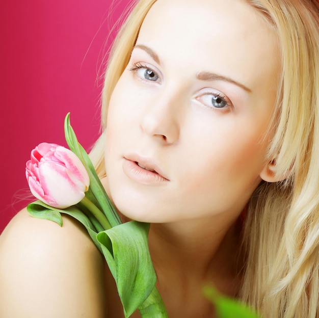 Mujer rubia con tulipán rosa