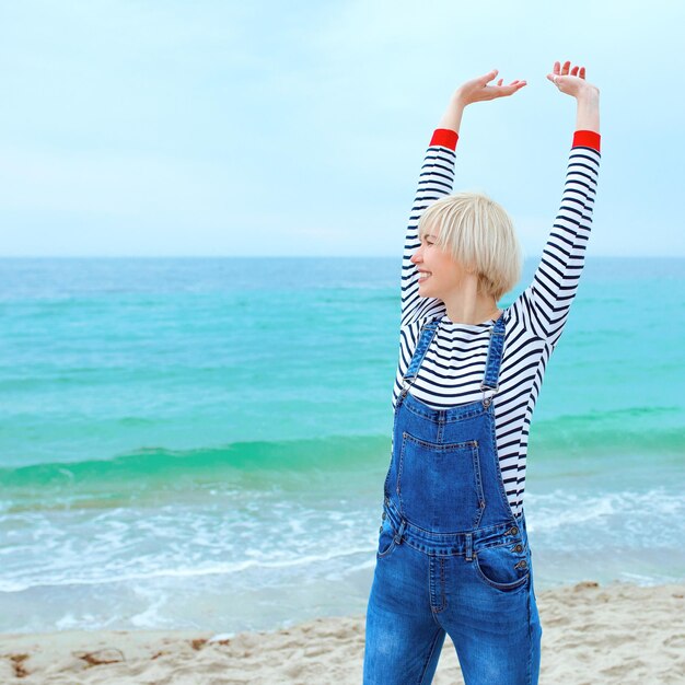 mujer rubia de vacaciones junto al mar