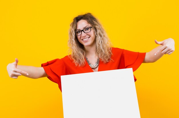 Mujer rubia vestida con cartel en blanco