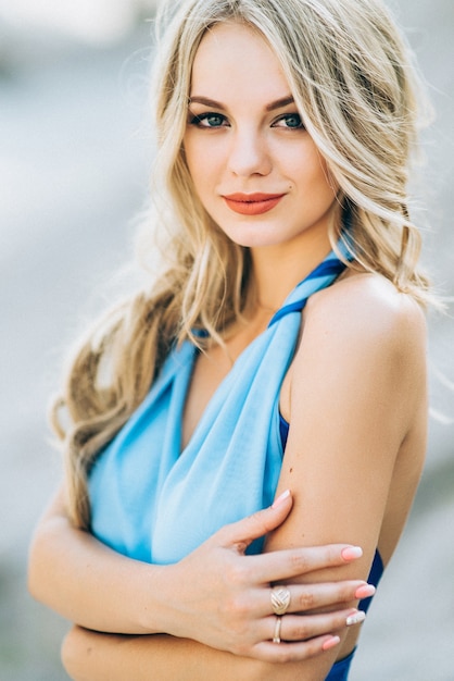 Mujer rubia con un vestido azul claro en una cantera de granito gris