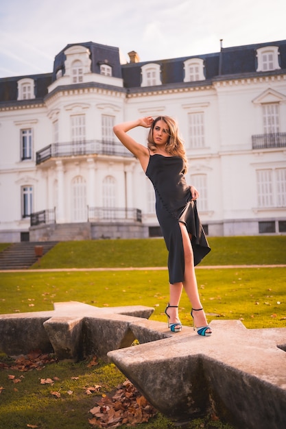 Mujer rubia con un vestido glamoroso y tacones azules