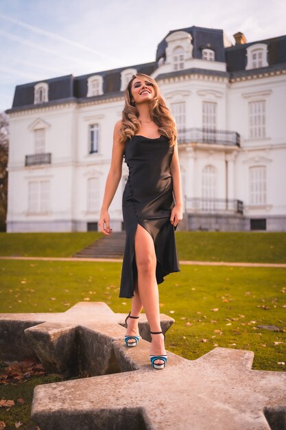 Mujer rubia con un vestido glamoroso y tacones azules