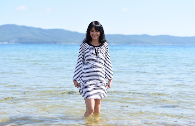 Mujer rusa de 45 años riendo y de pie en el mar japonés