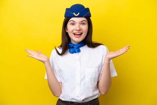 Mujer rusa de azafata de avión aislada de fondo amarillo con expresión facial sorprendida