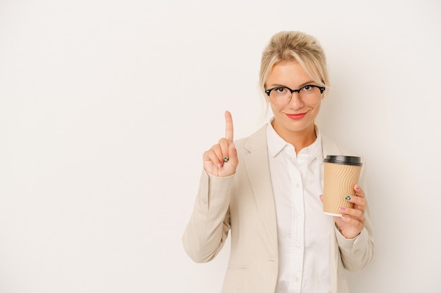 Mujer rusa de negocios joven sosteniendo café para llevar aislado sobre fondo blanco mostrando el número uno con el dedo.