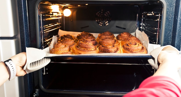 Mujer saca la deco con la panadería fresca del horno