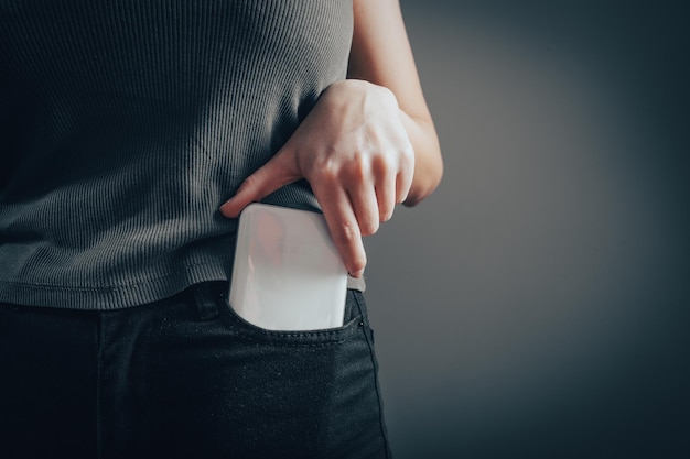 La mujer saca el teléfono de su bolsillo.