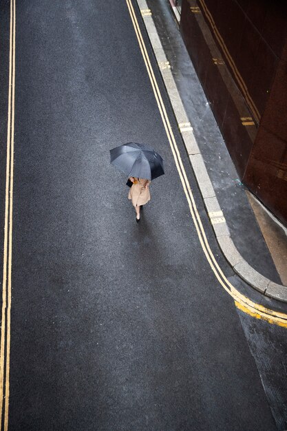 Mujer saliendo por la ciudad mientras llueve