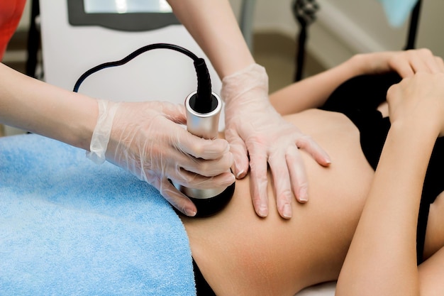 Una mujer en un salón de belleza recibe un masaje abdominal al vacío Cosmetología de hardware