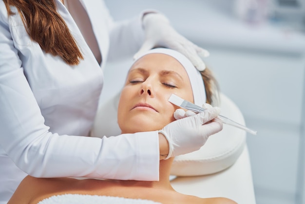 Mujer en un salón de belleza con tratamiento facial y corporal