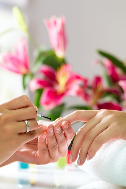 Mujer en salón de manicura recibiendo manicura