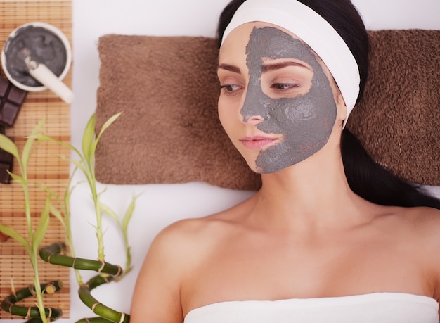 Mujer en el salón de spa con mascarilla