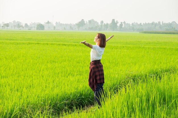 Una mujer salta alegremente en un campo soleado rodeada de la belleza de la naturaleza que encarna la libertad y la felicidad