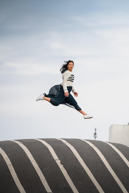 Mujer saltando en el aire contra el cielo