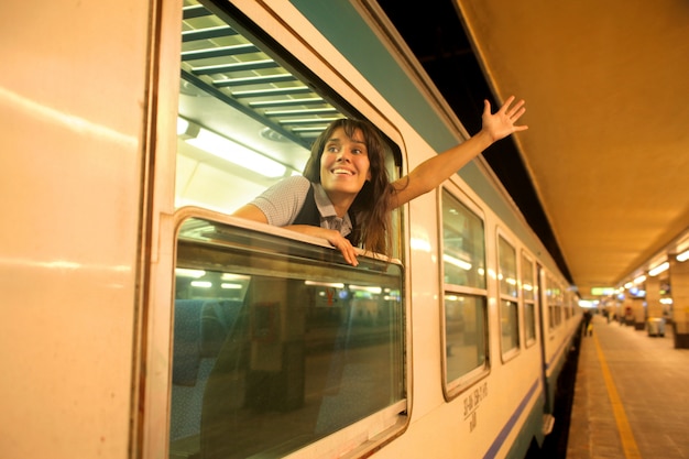 Mujer saludando desde un tren