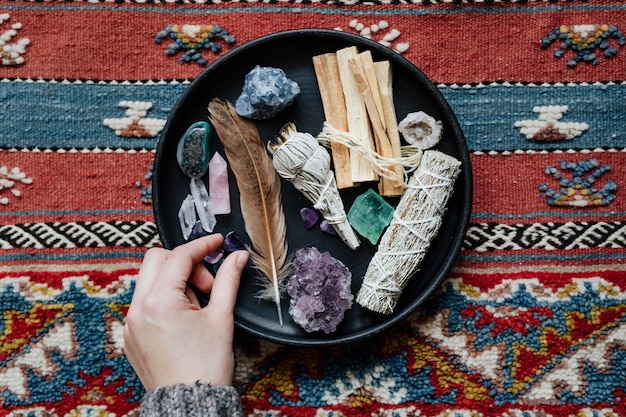 Mujer con salvia y cristales listos para manchar