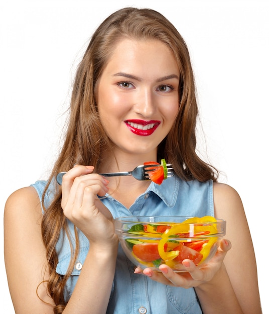 Mujer sana con ensalada sobre fondo blanco.