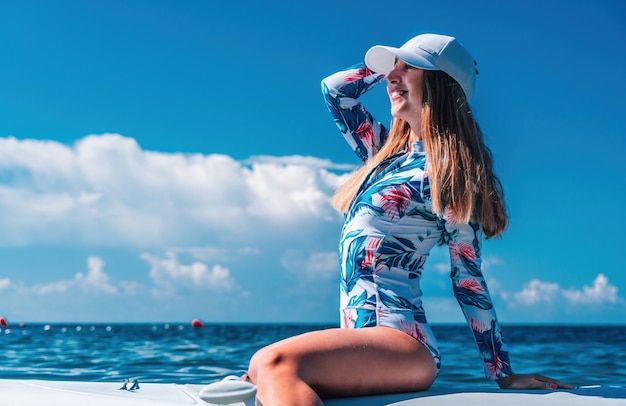 Mujer sana feliz en forma de bikini relajándose en una tabla de surf sup flotando en el mar turquesa claro