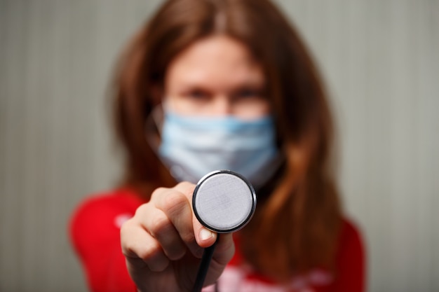 Foto mujer sana en máscara protectora médica azul. protección y prevención de la salud durante la gripe y los brotes infecciosos.
