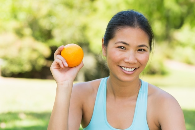 Mujer sana con naranja en el parque