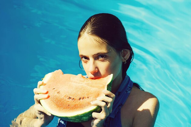 Mujer con sandía en piscina