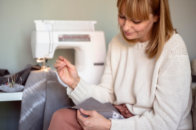 Mujer sastre con herramientas para coser telas