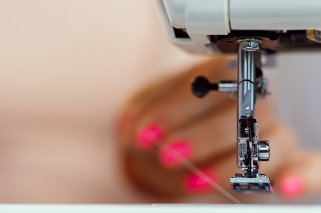 Mujer sastre el proceso de costura en la máquina de coser, vista cercana