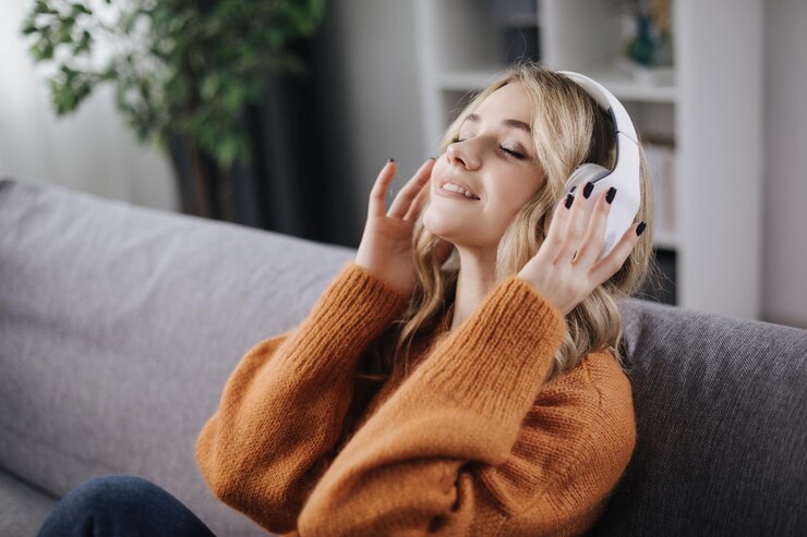 Mujer satisfecha disfrutando de la música en el sofá