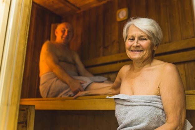 Una mujer en una sauna con un hombre en una toalla.