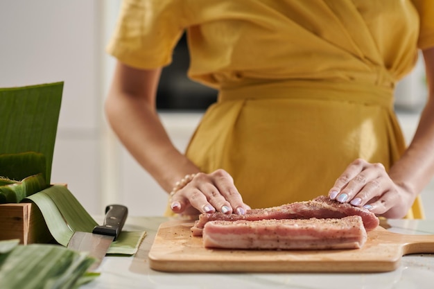 Mujer Sazonando Trozos De Cerdo