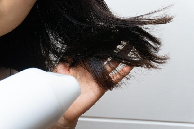 Una mujer secándose el pelo con un secador de pelo