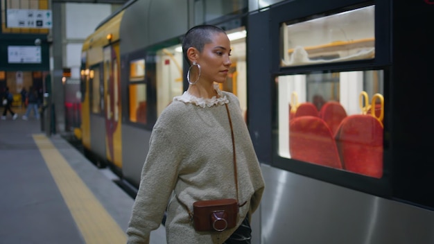 Mujer segura caminando en el tren llevando equipaje chica turista entrando en el transporte