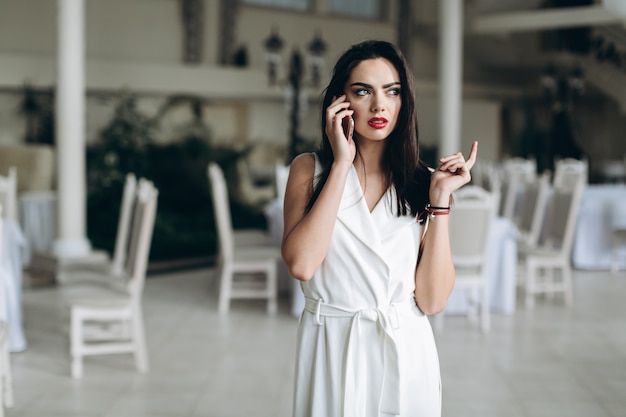 Mujer segura hablando por teléfono inteligente en el restaurante