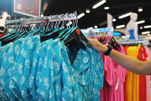 Mujer selecciona un vestido de mujer en una tienda