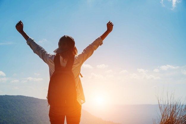 Mujer senderismo disfrutar de la hermosa vista a la montaña para la luz del sol