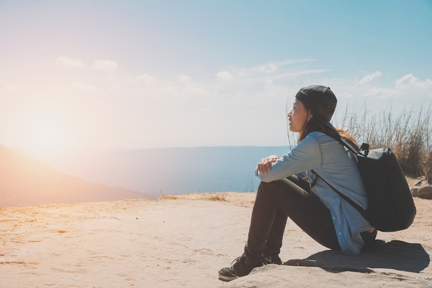 Mujer senderismo sentarse disfrutar de la hermosa vista a la montaña para la luz del sol