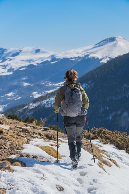 mujer senderista caminando por una ruta de montaña