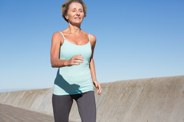 Mujer senior activa para correr en el muelle