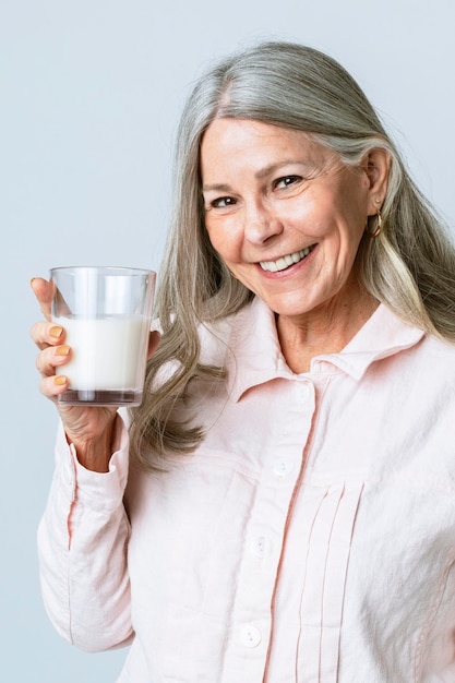 Mujer senior alegre bebiendo un vaso de leche