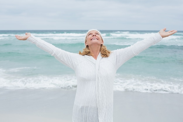 Mujer Senior con los brazos extendidos en la playa