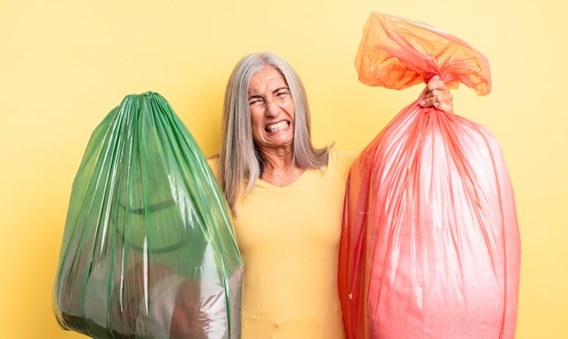 mujer senior de cabello gris. reciclar el concepto de basura